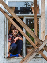 Portrait of smiling boy sitting in window