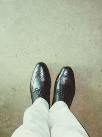 Low section of person standing on tiled floor