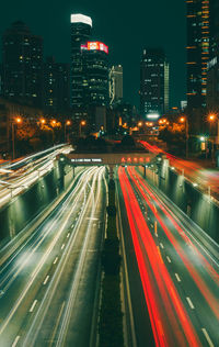 High angle view of light trails on road amidst buildings in city