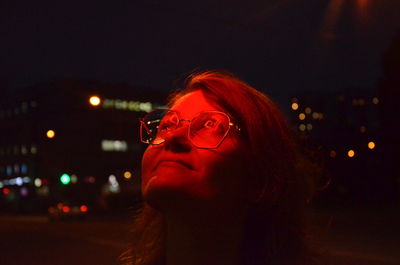 Portrait of young woman looking away at night