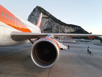 Airplane on airport runway against sky