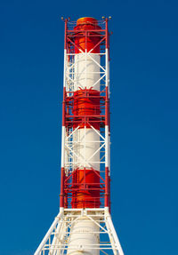 Low angle view of red tower against clear blue sky