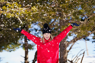 Close-up of person on snow covered tree during winter