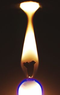 Close-up of lit candle in dark room