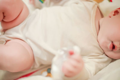 High angle view of cute baby girl lying on bed