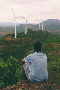 Rear view of man sitting on land