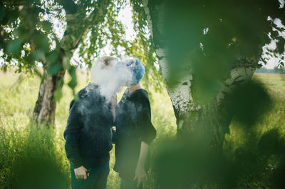 Young couple kissing while exhaling smoke