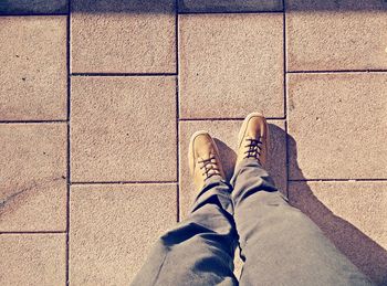 Low section of man standing on sidewalk