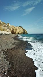 Rocks on beach against sky