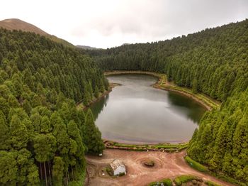 High angle view of lake amidst green landscape against sky