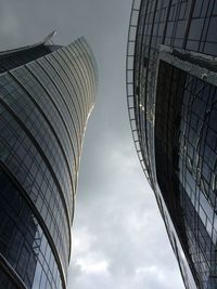 Low angle view of modern building against cloudy sky