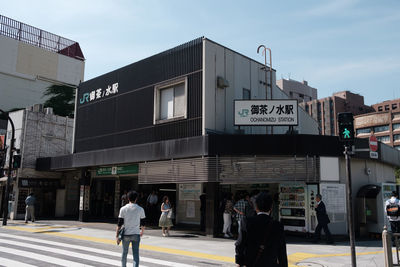 People walking on road against buildings