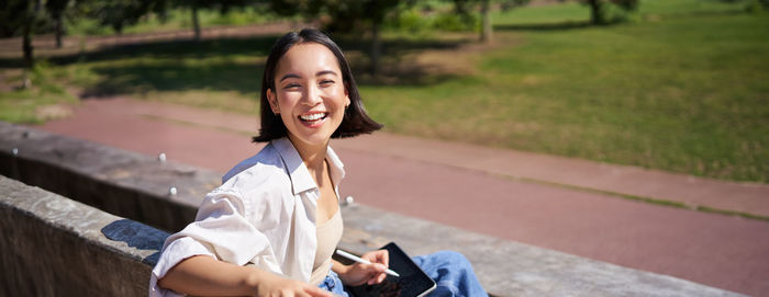 Portrait of young woman sitting on bench