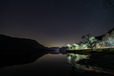 Scenic view of lake against sky at night