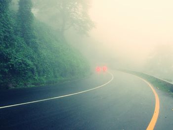 Road passing through foggy weather