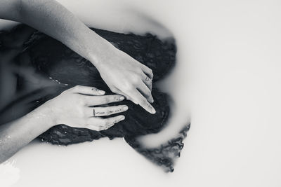 High angle view of woman hand holding leaf over white background