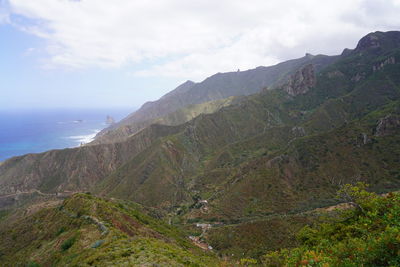 Scenic view of sea and mountains against sky