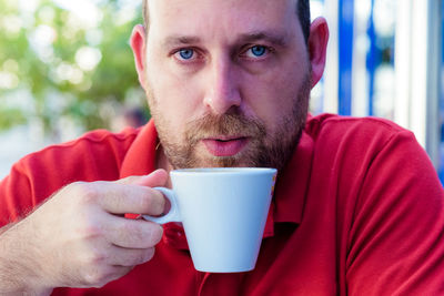 Portrait of man drinking coffee at outdoor cafe