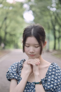 Girl looking away while standing against blurred background