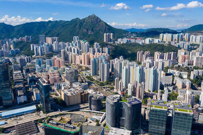 Aerial view of buildings in city against sky