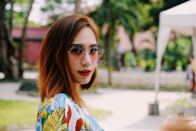 Side view portrait of woman wearing sunglasses at park