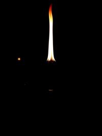 Close-up of lit candle in darkroom