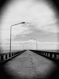 Pier on sea against cloudy sky