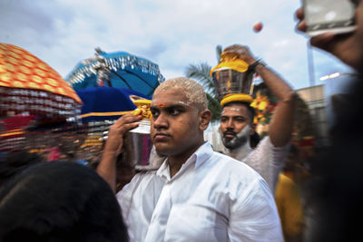 Group of people in amusement park against sky