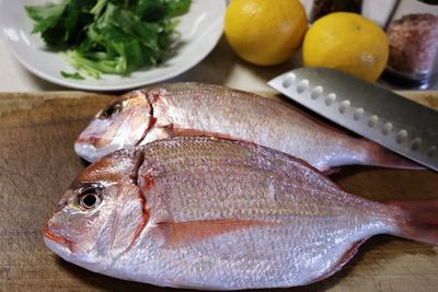 High angle view of fish on chopping board in kitchen