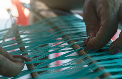 Cropped image of woman making wicker basket