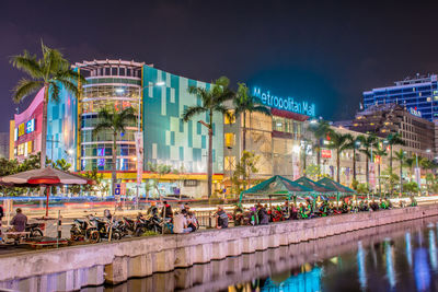 Illuminated buildings by swimming pool at night