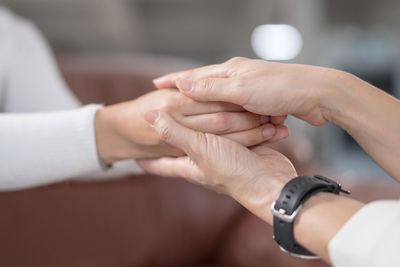 Midsection of couple holding hands