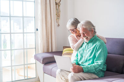 Woman using mobile phone while sitting at home