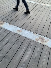 Low section of person standing on boardwalk