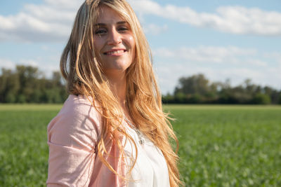 Portrait of young woman standing on field