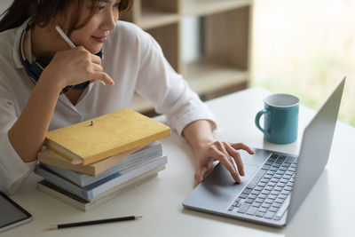 Midsection of woman using laptop on table