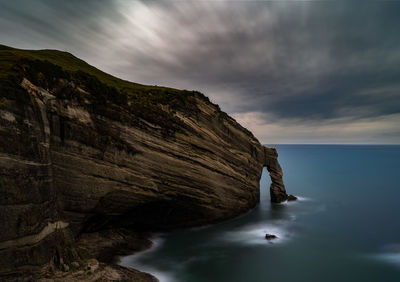 Rock formations by sea against sky