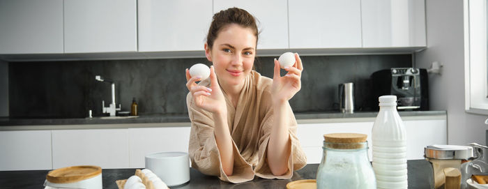 Portrait of young woman drinking coffee at home