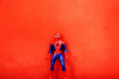 Full length of man standing against red wall