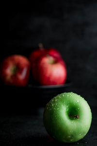 Close-up of apples on table against black background