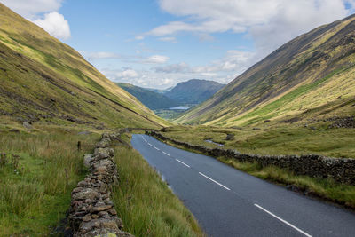 Road amidst green landscape against sky