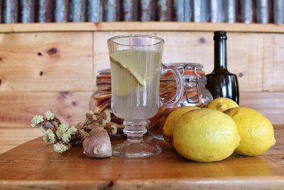 Close-up of drink by lemons on table