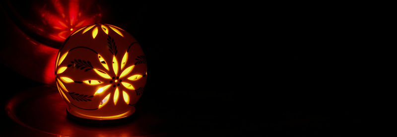 Close-up of illuminated lamp in darkroom