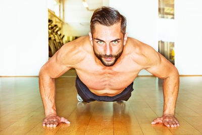 Close-up portrait of muscular man exercising in gym