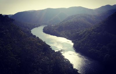 Scenic view of river and mountains against clear sky