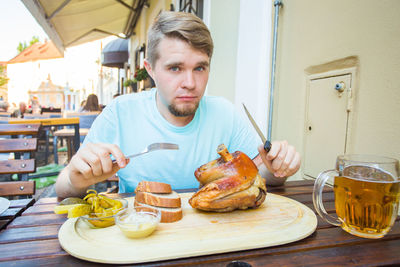 Portrait of man having food on table