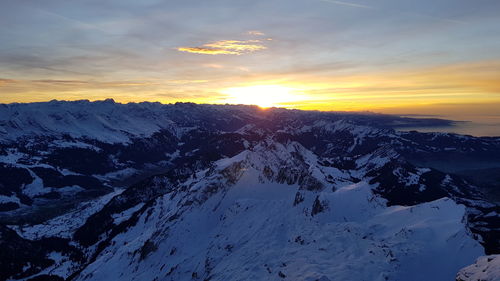 Scenic view of snowcapped mountains against sky during sunset