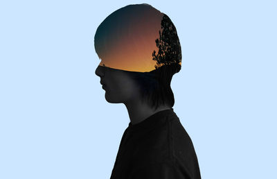 Double exposure tree at sunset and man against blue background