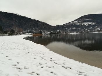 Scenic view of lake and snowcapped mountains against sky