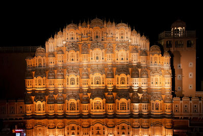 Low angle view of illuminated building against sky at night